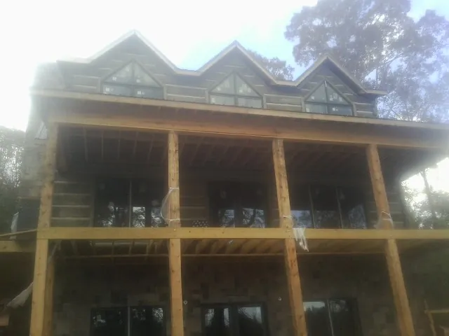 Dormers and porch framing on a large log home under construction — Roof Coating work by our crew in Alsip